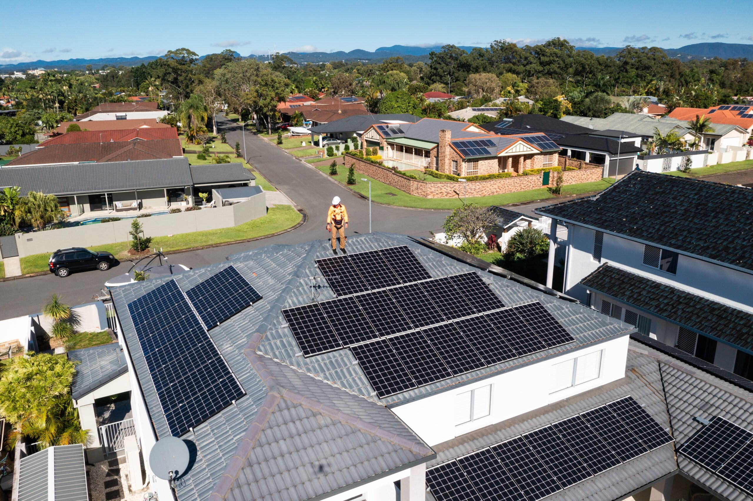 Solar panels and technician on a home on a sunny day.